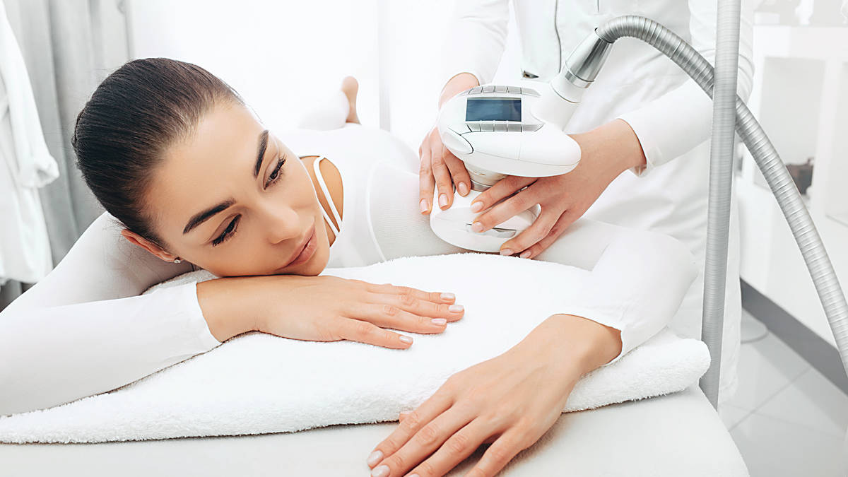 A woman receives an Endermologie, a body contouring treatment at a spa, using a modern device for relaxation and wellness.